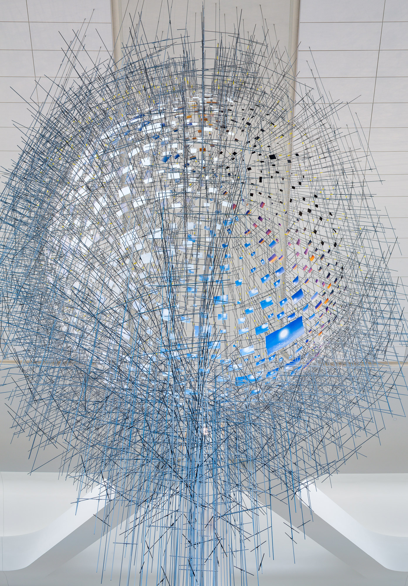 An intricate constellation of hundreds of photographs forming a mirage-like sphere that appears to float in midair.