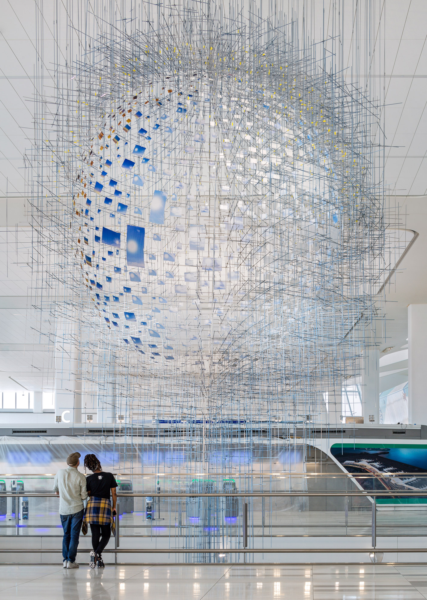 An intricate constellation of hundreds of photographs forming a mirage-like sphere that appears to float in midair.