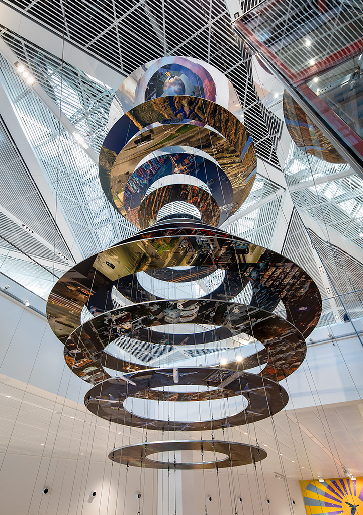 Slices of New Jersey skyline photographs are suspended in two large helix-like structures, hanging from the inside of an airport terminal.