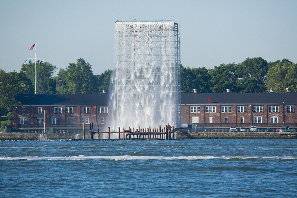 A grand cascading waterfall at the waterfront of a river.