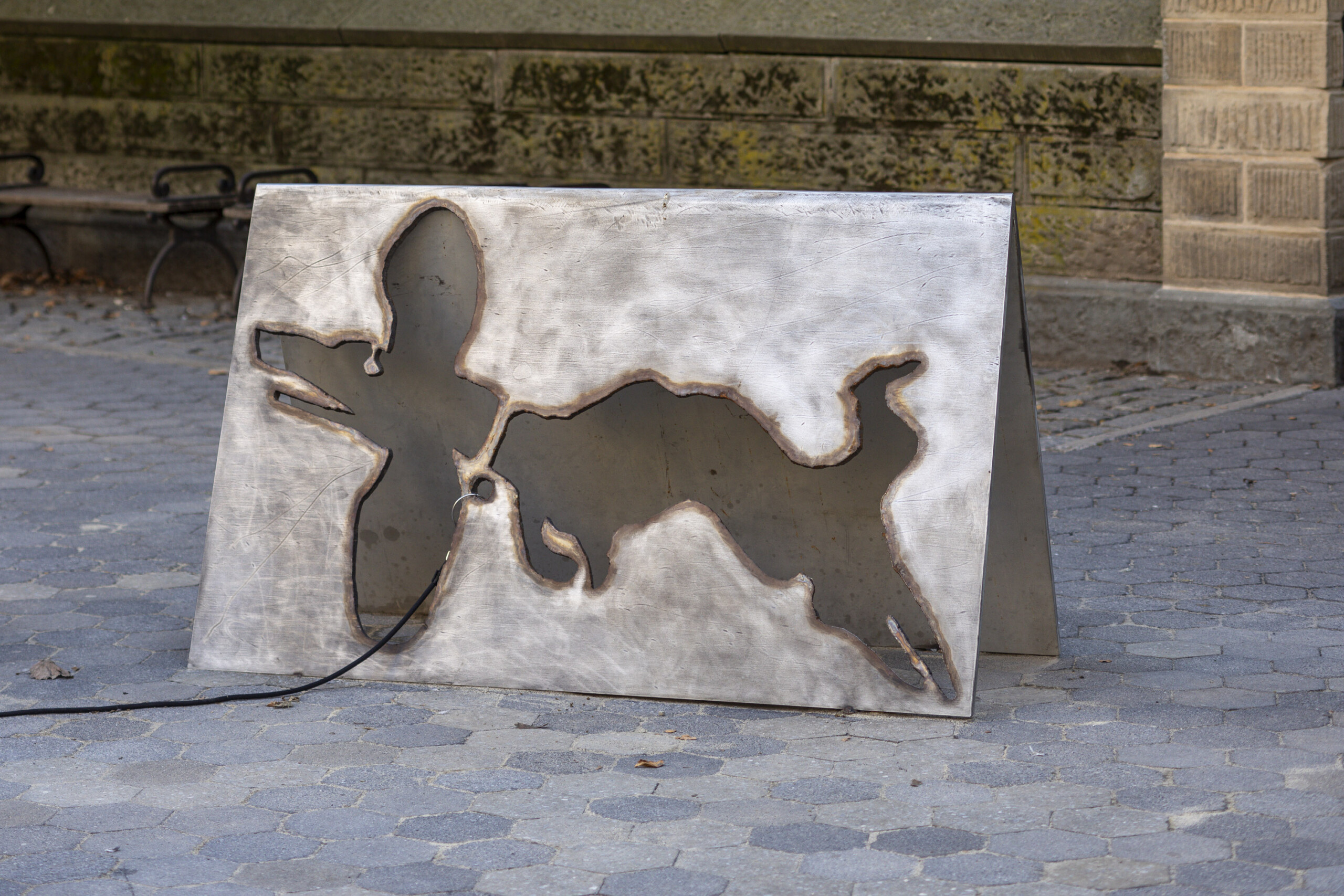a sculpture of a negative image of a dog cut out of a sheet of steel