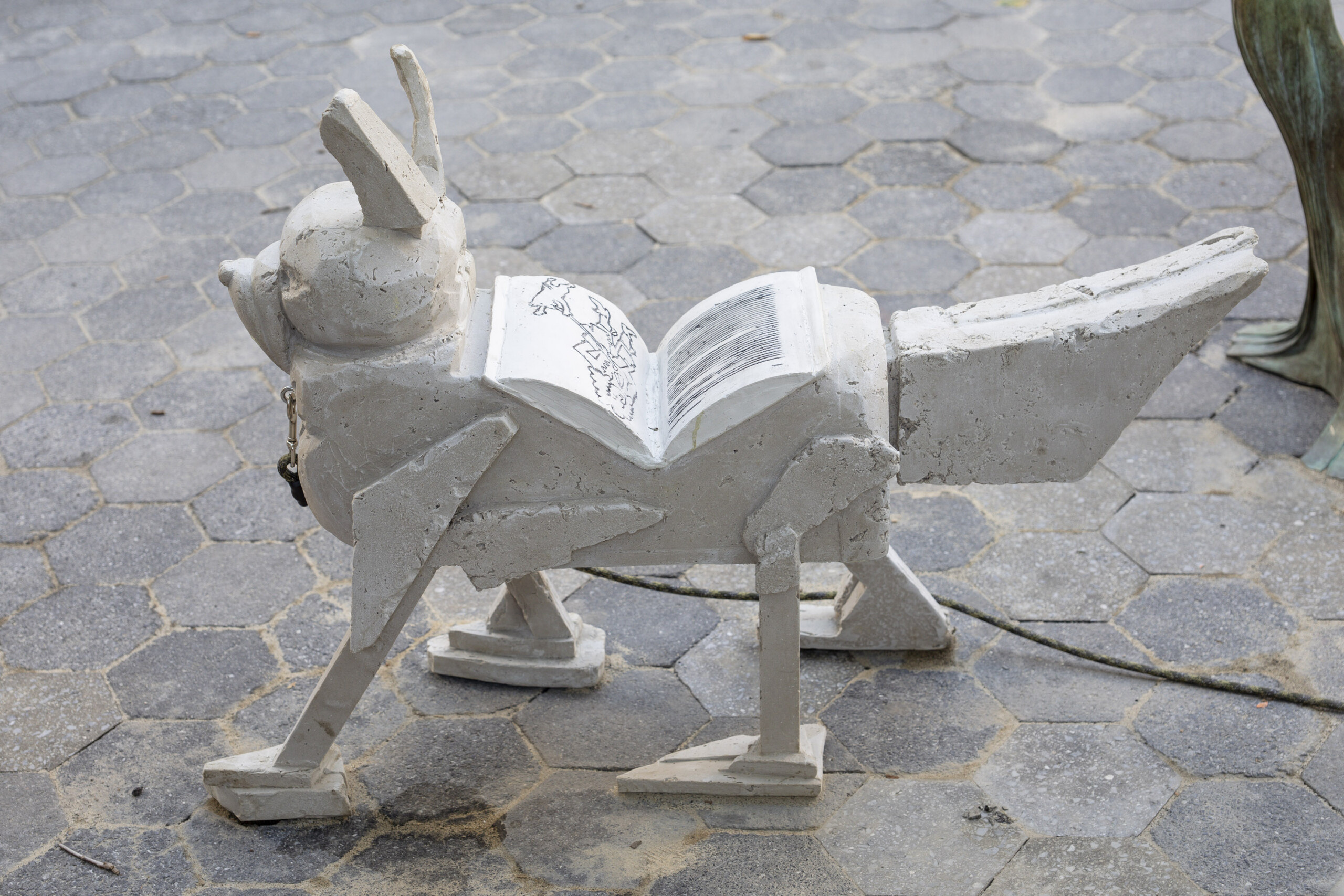 a sculpture of a white dog with a book on its back
